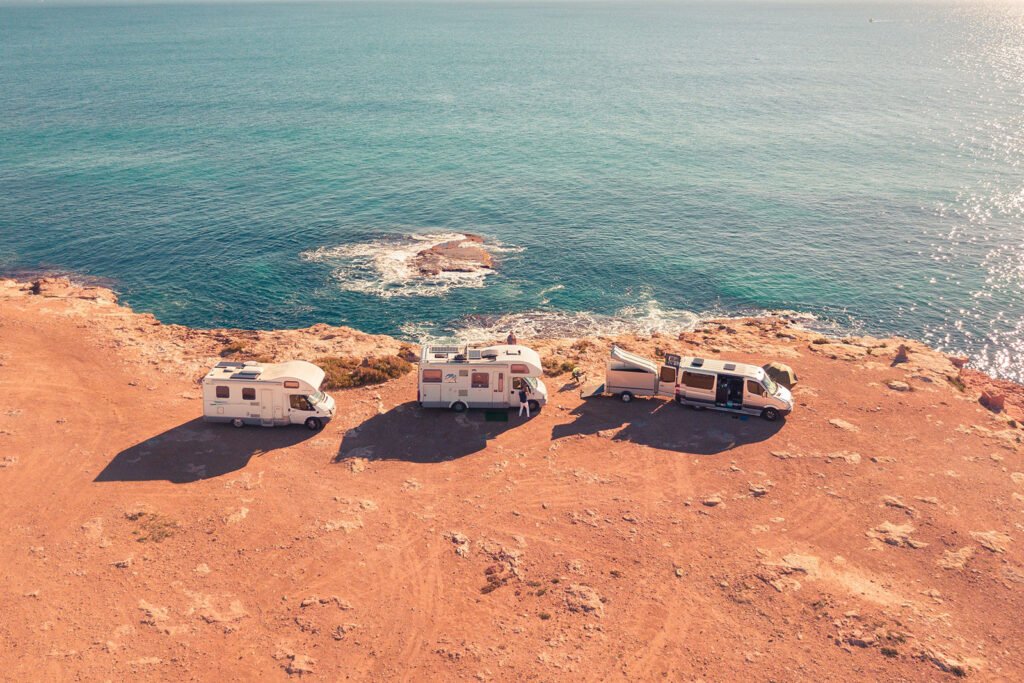 Stock image of aerial view of 3 RVs parked along the coast